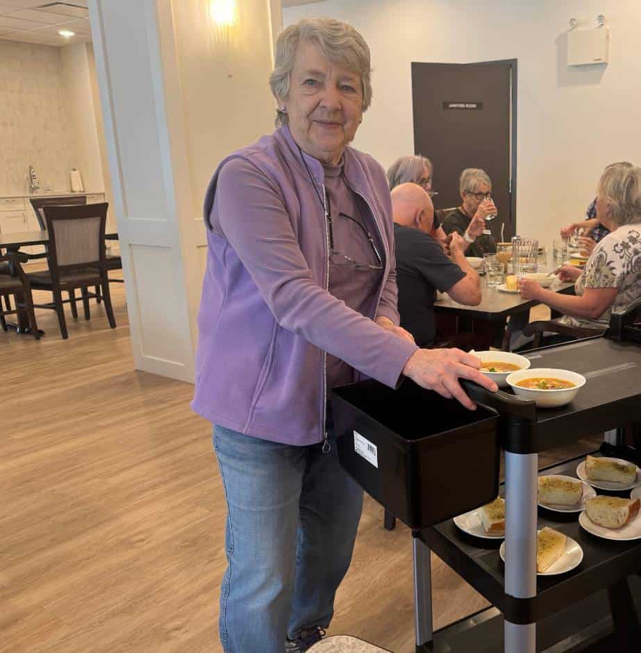 A Three Robins Riverside resident serving lunch in the community kitchen