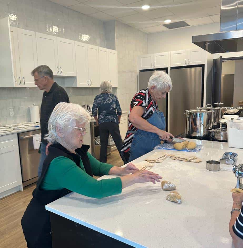 a group of Three Robins Riverside residents making bread in the community kitchen