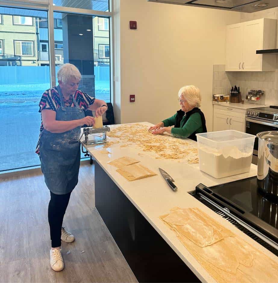 Two people preparing pasta together.