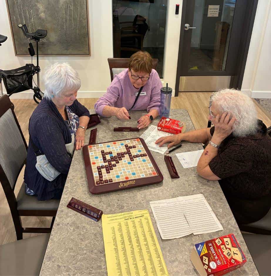 Three ladies playing Scrabble together.