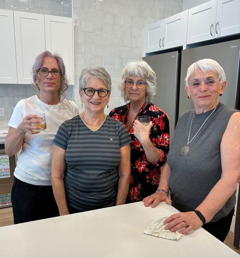 Four women socializing in the Three Robins Community kitchen.