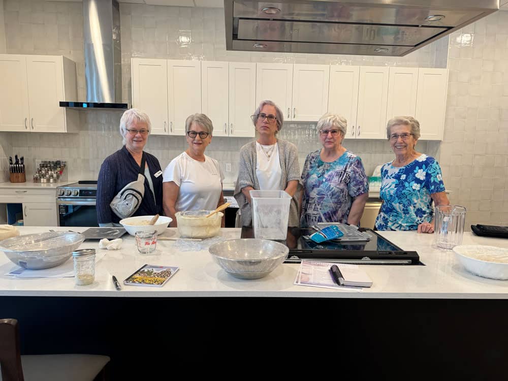 group of ladies cooking sour dough bread together as the Food Club at Three Robins Riverside